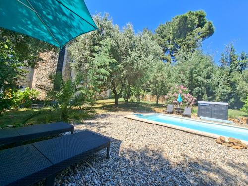 a swimming pool in a yard with a bench at Chalet Le Petit olivier , gite l Echapée Belle Aubenas in Aubenas