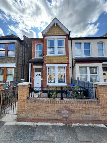 a brick house with a fence in front of it at Absam Homes in London
