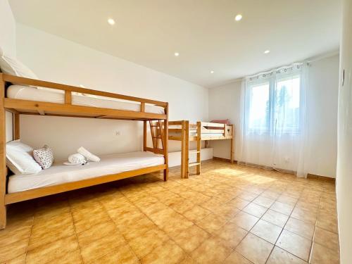 a room with two bunk beds and a window at Romarin Haut villa 2 bedrooms Air conditioning garden in La Roquette-sur-Siagne
