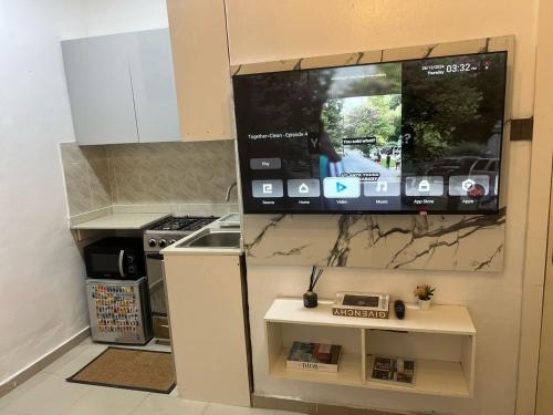 a kitchen with a tv hanging on a wall at 7th generation apartments limited in Lagos