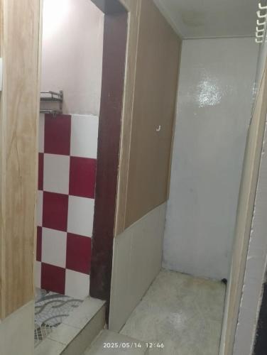 a bathroom with a red and white checkered wall at Amazing Homestay in Guwahati