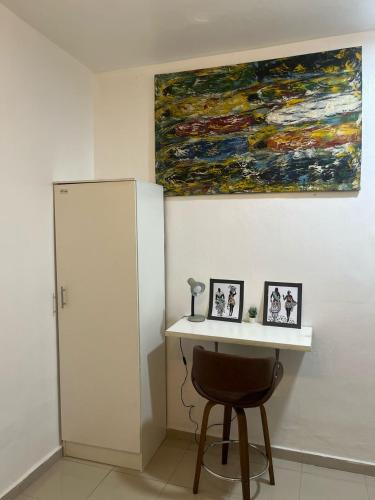 a table with a chair and a painting on the wall at 7th generation apartments limited in Lagos
