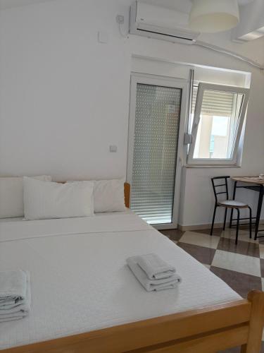 a bedroom with a large white bed with two towels on it at Vila Vavilon in Star Dojran
