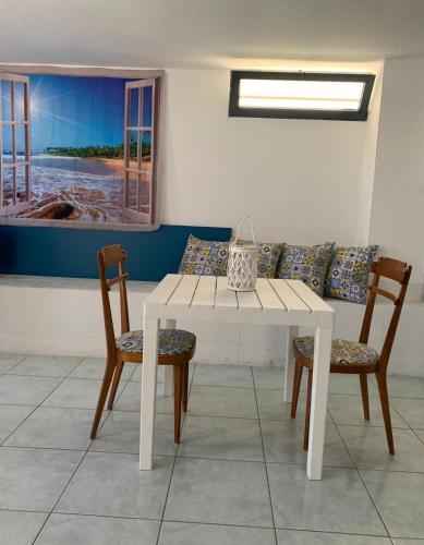 a white table and two chairs and a couch at Dimora Terra di Puglia in Torre Santa Sabina