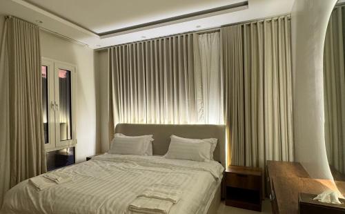 a bedroom with a large bed in front of windows at شقة مميزه بتصميم عصري in Baljurashi