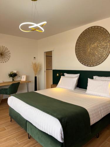 a bedroom with a large bed and a ceiling fan at Le Domaine de la Vallée in Vernon
