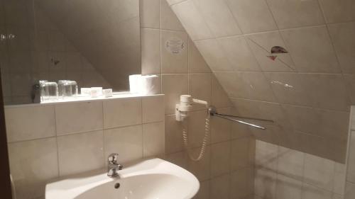 a white bathroom with a sink and a shower at Hotel Ziegenkrug Schweriner Tor in Pampow