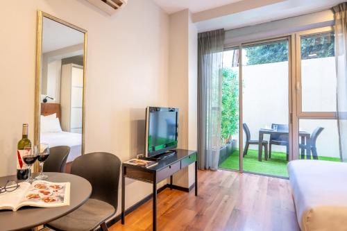 a living room with a television and a table with chairs at Sea Land Suites in Tel Aviv