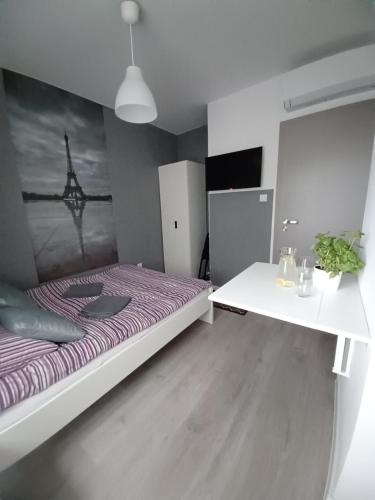 a bedroom with a bed and a white table at Villa Marina in Augustów