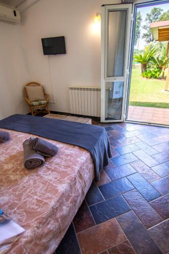 a bedroom with a bed and a sliding glass door at LA CESA Holiday House in San Felice Circeo