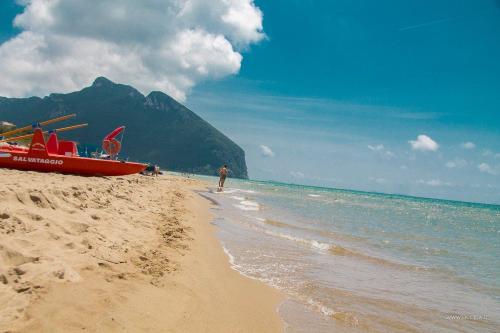 a man standing on a beach next to a boat at LA CESA Holiday House in San Felice Circeo