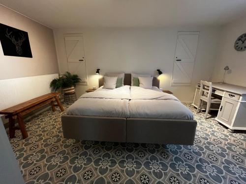a bedroom with a large bed and a desk at B&B appartement Rebel and Moon in het centrum van Alblasserdam in Alblasserdam