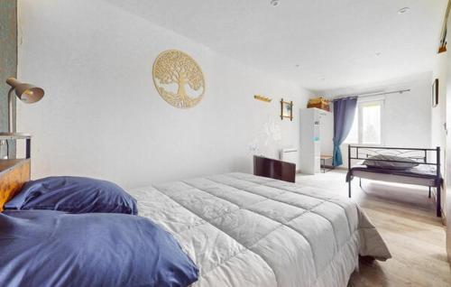 a bedroom with a large bed and a clock on the wall at La scierie Massonat in Cossaye