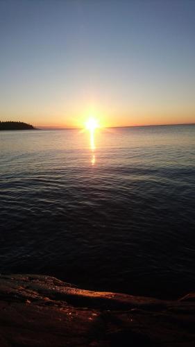 a sunset over a large body of water at Örrud Örsgärde, Värmlands Näs Säffle kommun in Herräng