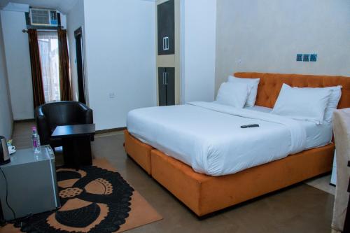 a bedroom with a large bed and a desk at Zoey International Hotels Ltd in Owerri