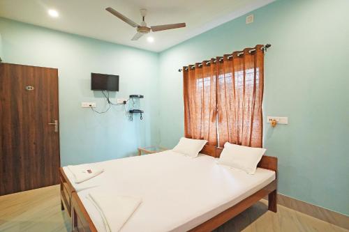 a bedroom with a bed and a window at Whispering Woods Inn - Stay & Enjoy in Nature ! in Bolpur