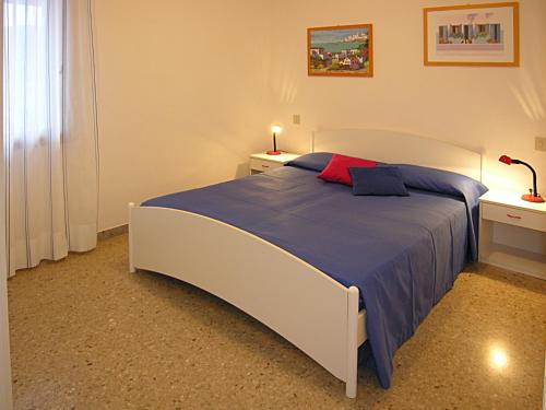 A bed or beds in a room at Appartamenti Nettuno Pineda