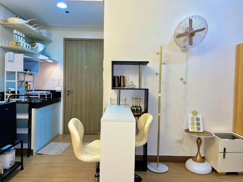 a kitchen with a table and chairs and a fan at Auberge Condotels B at SMDC Hope Residences in Trece Martires