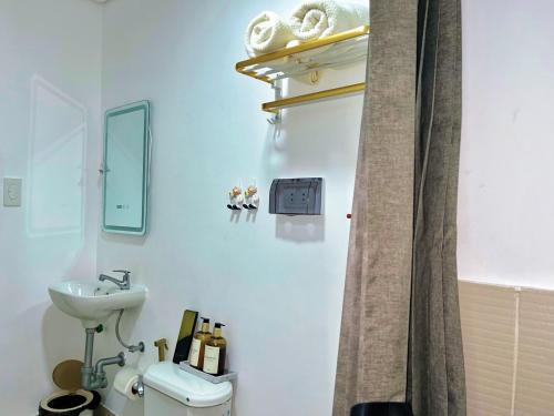 a bathroom with a sink and a toilet and a mirror at Auberge Condotels B at SMDC Hope Residences in Trece Martires