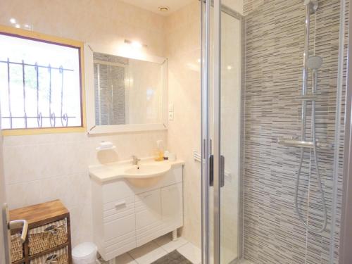 une salle de bain blanche avec un lavabo et une douche dans l'établissement Les lavandes, à Mézos