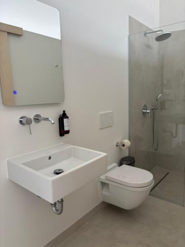 a bathroom with a sink and a toilet and a mirror at Købmandsgården, Ballen in Ballen