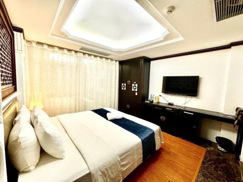ハノイにあるChurch Legend Hotelの大きなベッドとテレビのある寝室