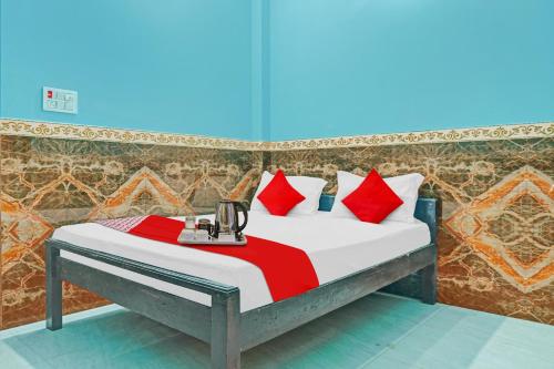 a bed with red pillows in a room at Hotel O B K Brothers in Gulzārbāgh