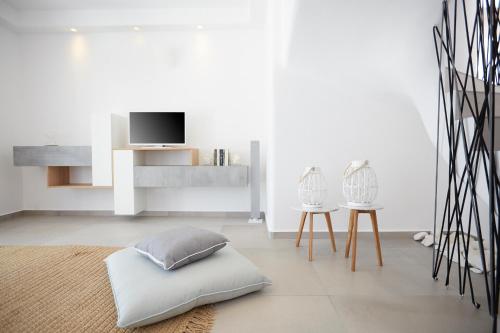 a living room with a bed and two chairs at Amor Hideaway Villas in Fira