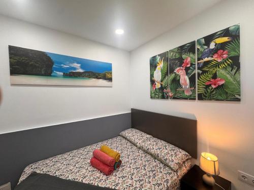 a bedroom with a bed with two paintings on the wall at 4'min to beach and tren 15 min to plaza catalunya by tren in Sant Adria de Besos