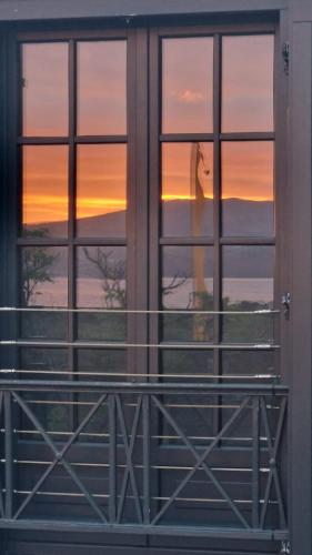 a woman looking out of a window at the sunset at Solar dos limas in Criação Velha