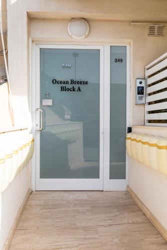 Una puerta de vidrio con un cartel que dice Bloque Brisa del Océano en Modern&quiet ensuite room, en St Paul's Bay