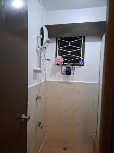 a bathroom with a shower and a window with flowers at Reddy Residence in Naulu