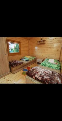 a bedroom with two beds and a window at Domki letniskowe Wrzoski in Kamień Pomorski