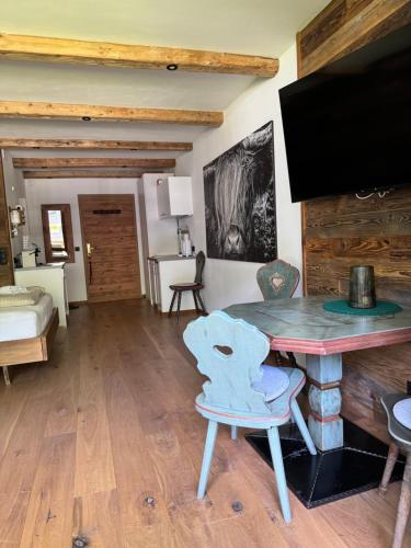 a living room with a table and a tv at Chalet-Stil mit Pool und Bergblick in Sankt Martin bei Lofer