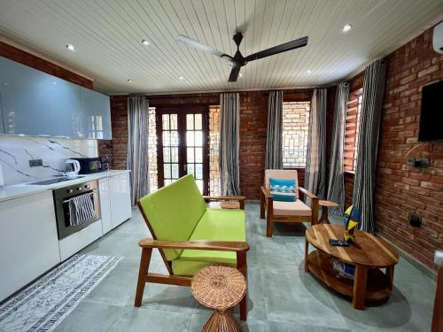 a living room with a green chair and a table at 1 Bedroom Sunset & Mountain View Chalet in Aburi in Aburi