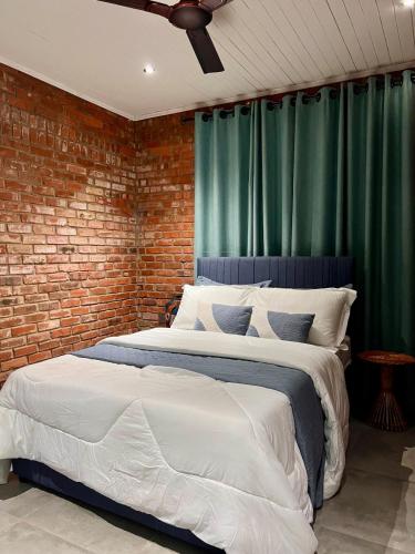 a bedroom with two beds and a brick wall at 1 Bedroom Sunset & Mountain View Chalet in Aburi in Aburi