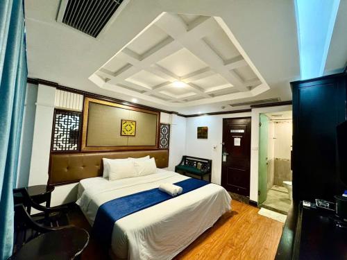 ハノイにあるChurch Legend Hotelの青い毛布が掛けられた大きなベッドのある寝室