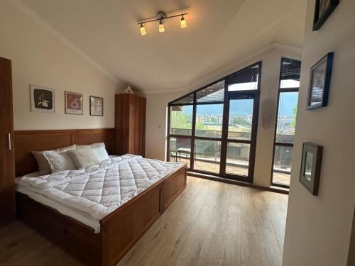 Un dormitorio con una cama grande y una ventana grande. en Top floor and mountain views, en Razlog