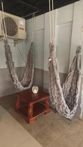 a room with two hanging hammocks and a table at The Sunshine hostel and hotel in Ko Lanta
