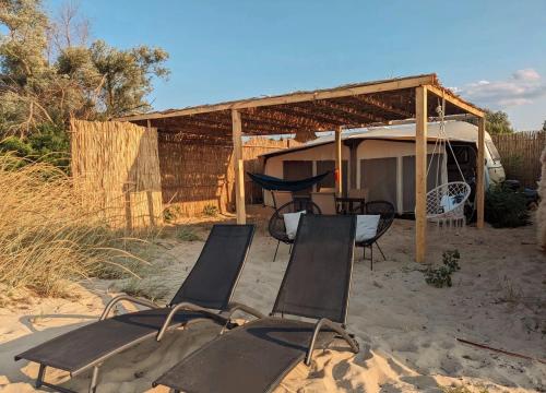 a group of chairs sitting in the sand in front of a tent at Каравана The Jungle in Chernomorets