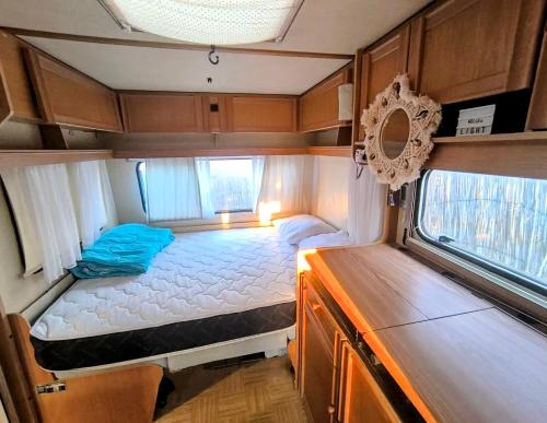 a small room with a bed in the back of an rv at Каравана The Jungle in Chernomorets