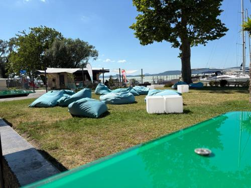 a group of pillows on the grass next to a pool at BL Residence Balatonlelle in Balatonlelle