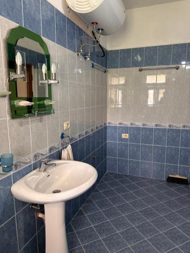 a bathroom with a sink and a mirror at BLEAM Guest House in Përmet
