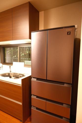 a kitchen with a stainless steel refrigerator and a sink at 墨松居 in Osaka