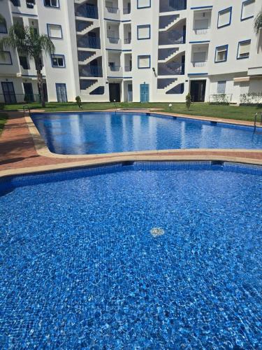 a large blue swimming pool in front of a building at رياض صوفيا باي مرتيل in Martil