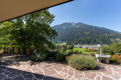 a patio with a bench and mountains in the background at Haus Sonnenschein in Obervellach