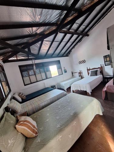 a large bedroom with two beds and a ceiling at Hostel chapéu e praia in Prado