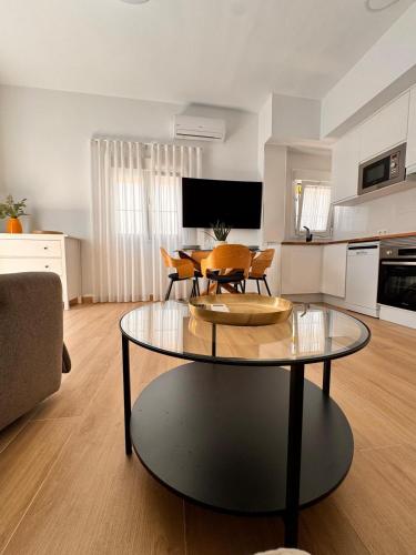 een woonkamer met een tafel en een keuken bij Apartamento Carmen Centro in Nerja