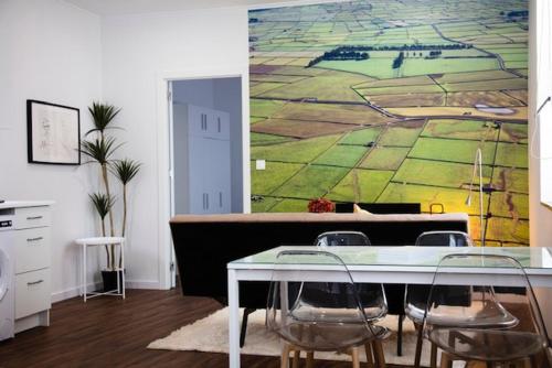 a dining room with a table and chairs and a painting at Cristal apartamento 1 esq Monte Brasil in Angra do Heroísmo