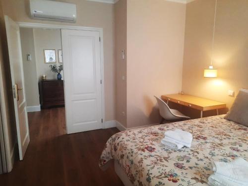 a hotel room with a bed and a desk and a door at Cerveira House in Vila Nova de Cerveira